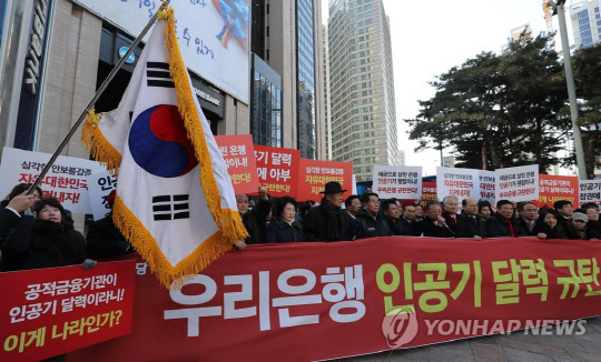 자유한국당 중앙직능위원회 위원들이 3일 오후 서울 중구 우리은행 본점 앞에서 우리은행의 탁상달력 사진에 북한 인공기가 등장한 것을 규탄하는 기자회견을 하고 있다.